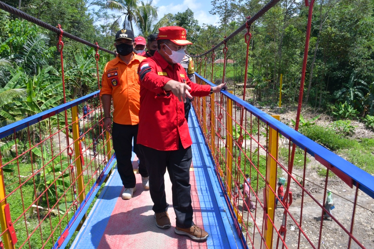 Warga Nekat Lewat Jembatan Gantung, Jalan Rusak Parah Jadi Dalang